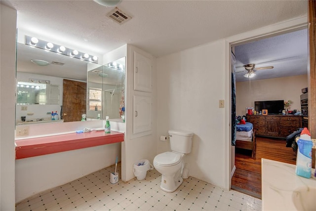 bathroom featuring a textured ceiling, vanity, ceiling fan, hardwood / wood-style flooring, and toilet