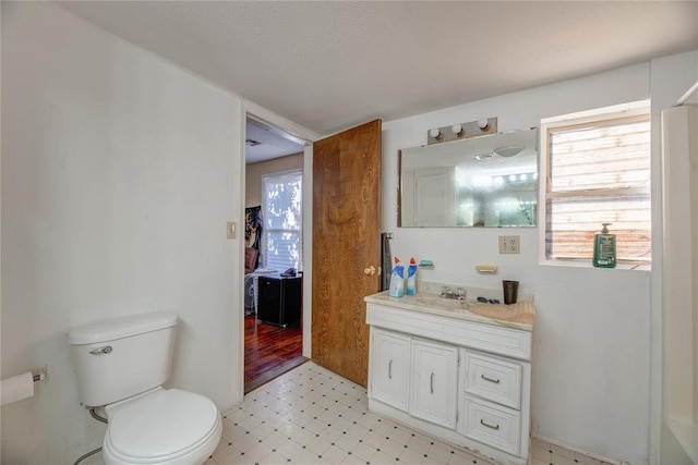 bathroom featuring vanity, toilet, and a healthy amount of sunlight