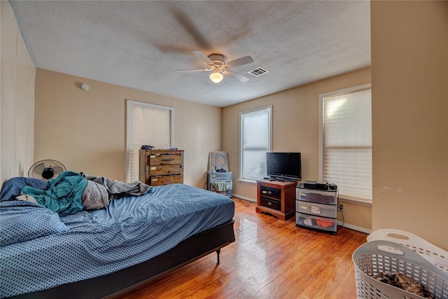 bedroom featuring a textured ceiling, hardwood / wood-style flooring, and ceiling fan