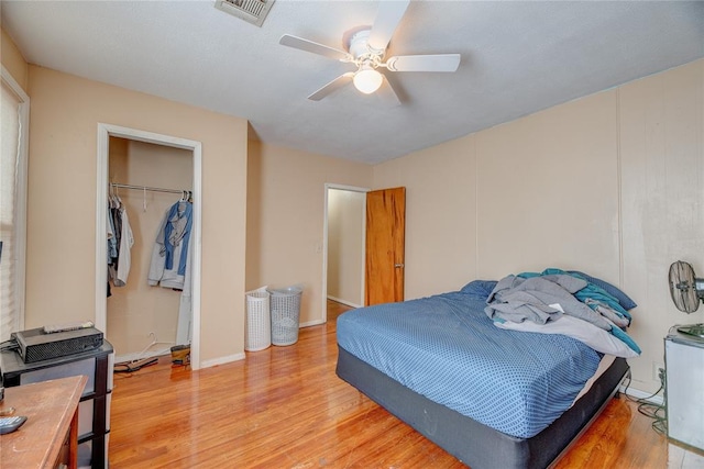 bedroom with a closet, light hardwood / wood-style flooring, and ceiling fan