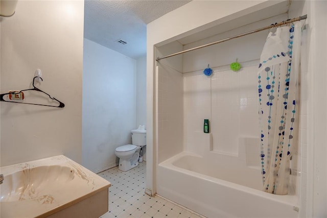 full bathroom featuring vanity, toilet, a textured ceiling, and shower / tub combo