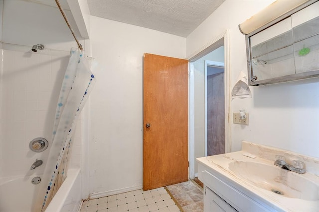 bathroom with shower / bath combo, vanity, and a textured ceiling