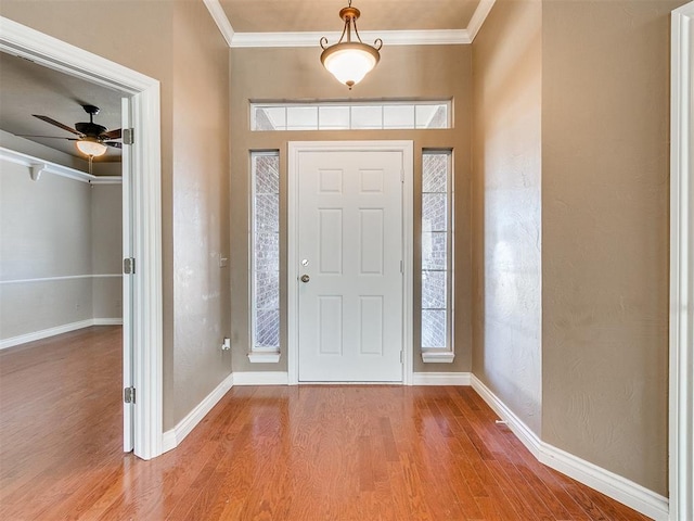 foyer with ceiling fan, ornamental molding, and hardwood / wood-style flooring