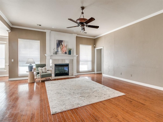 living room with hardwood / wood-style floors, ornamental molding, ceiling fan, and a healthy amount of sunlight