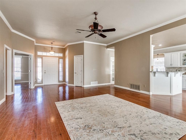 entrance foyer featuring dark hardwood / wood-style floors, ceiling fan, and ornamental molding