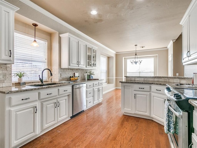 kitchen with a healthy amount of sunlight, stove, white cabinets, and stainless steel dishwasher