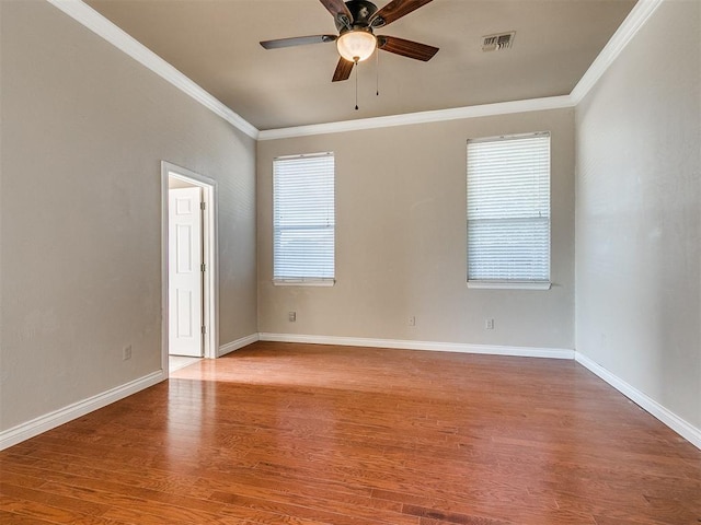 unfurnished room with a healthy amount of sunlight, crown molding, and wood-type flooring