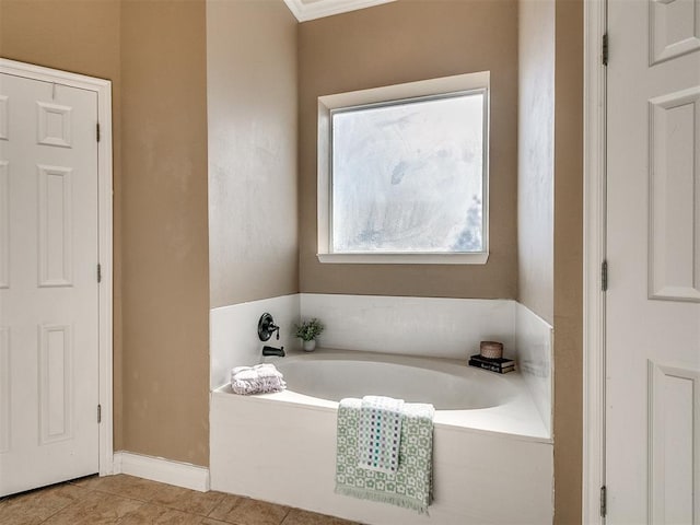 bathroom featuring tile patterned flooring, ornamental molding, and a tub to relax in