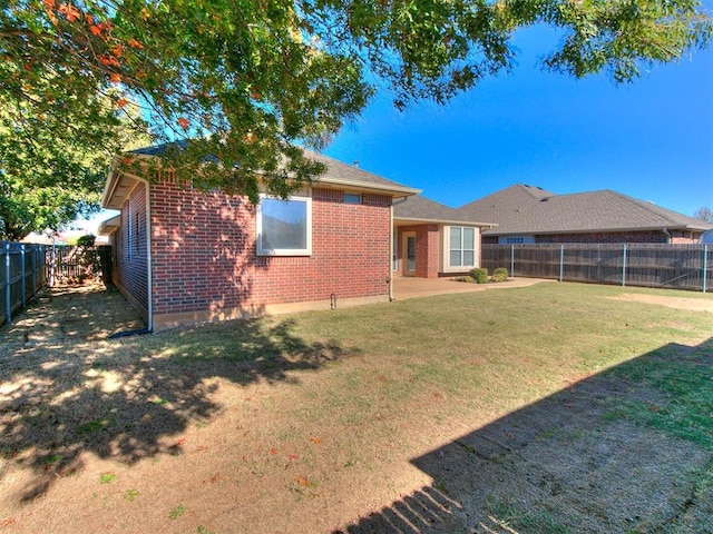 back of property featuring a lawn and a patio area