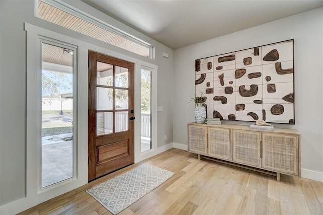 doorway to outside with plenty of natural light and light hardwood / wood-style floors