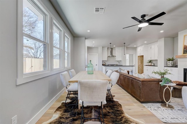 dining area with ceiling fan and light hardwood / wood-style flooring