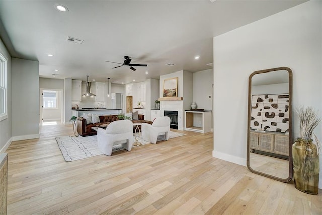 living room with ceiling fan and light wood-type flooring