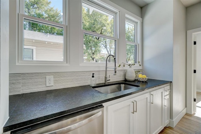 kitchen featuring dishwasher, white cabinetry, sink, and tasteful backsplash