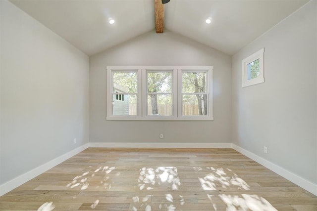 empty room featuring vaulted ceiling with beams and light hardwood / wood-style floors