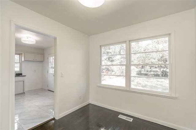 unfurnished room featuring wood-type flooring and a wealth of natural light