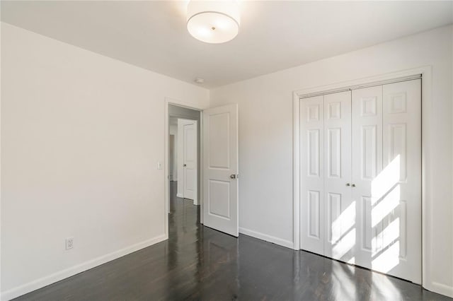 unfurnished bedroom featuring dark hardwood / wood-style flooring and a closet