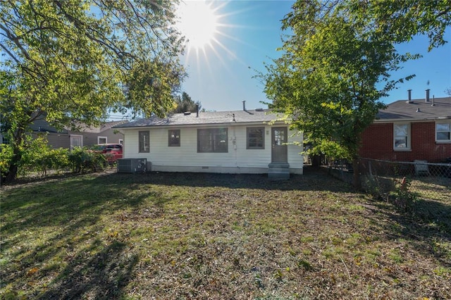 rear view of property featuring a yard and central AC