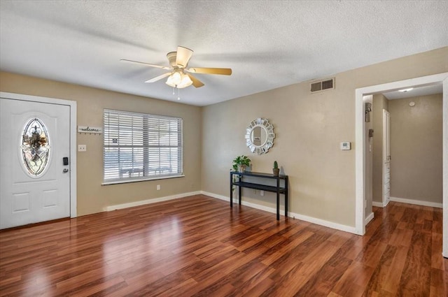 foyer featuring a textured ceiling, ceiling fan, and dark hardwood / wood-style floors