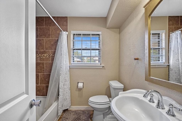 full bathroom with a textured ceiling, toilet, sink, and a wealth of natural light