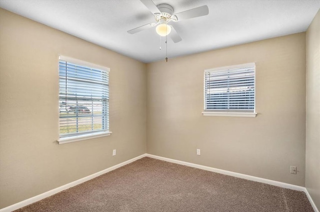 carpeted spare room featuring ceiling fan