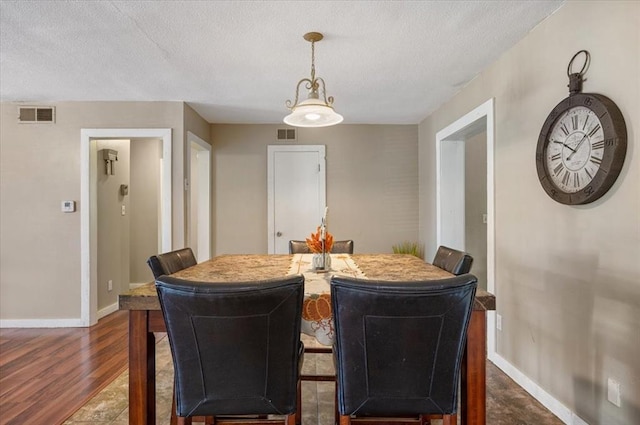 dining area featuring a textured ceiling and dark wood-type flooring