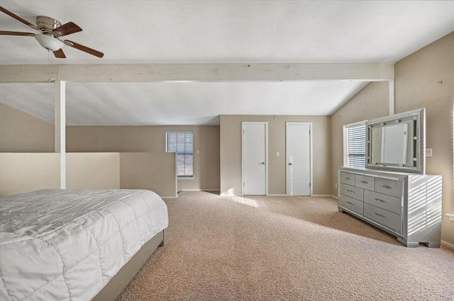 carpeted bedroom featuring multiple windows, ceiling fan, and lofted ceiling with beams