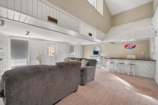 living room with carpet flooring, sink, and a high ceiling