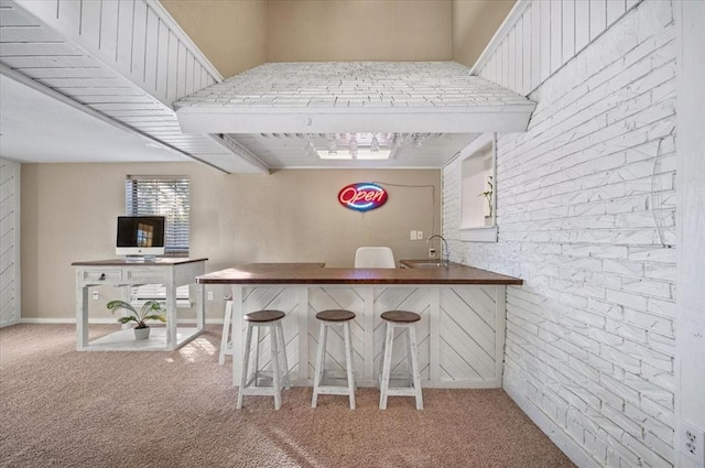 bar with white cabinets, sink, beamed ceiling, and light colored carpet