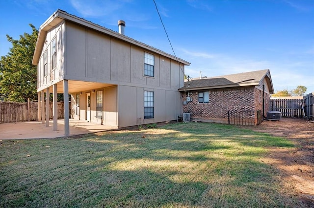 rear view of property featuring a patio area, a yard, and cooling unit