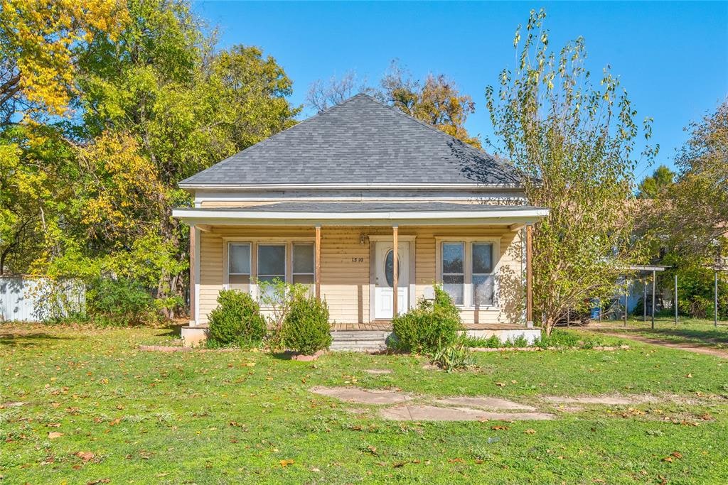 bungalow-style home featuring covered porch and a front yard