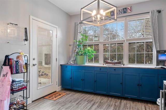 doorway to outside featuring light wood-type flooring and an inviting chandelier