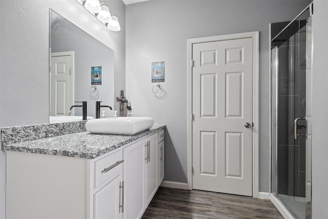 bathroom with hardwood / wood-style floors, vanity, and walk in shower