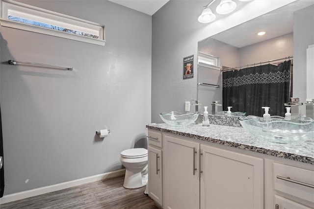 bathroom with a shower with shower curtain, vanity, toilet, and hardwood / wood-style floors