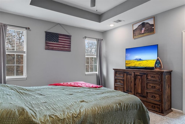 bedroom with visible vents, a tray ceiling, recessed lighting, carpet flooring, and baseboards