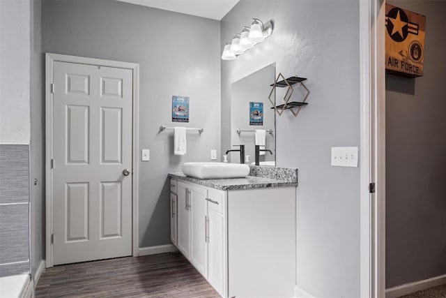 bathroom featuring vanity, wood finished floors, and baseboards