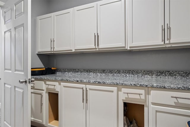 interior space featuring white cabinetry and light stone countertops