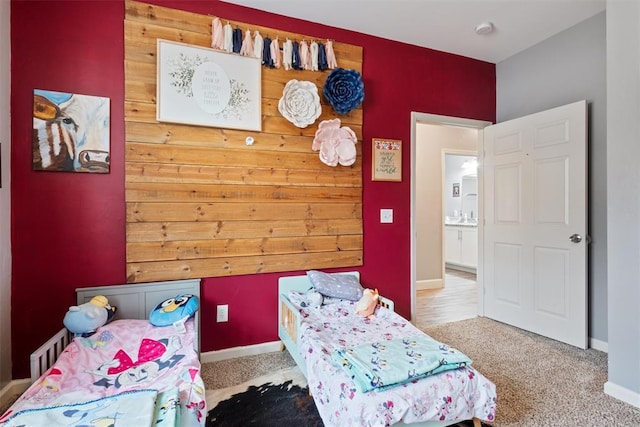 bedroom featuring wooden walls, baseboards, and carpet floors