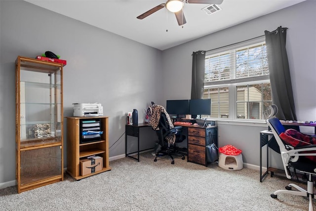 carpeted office space featuring baseboards, visible vents, and ceiling fan