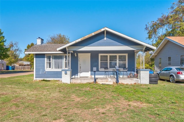 bungalow-style house featuring covered porch and a front lawn