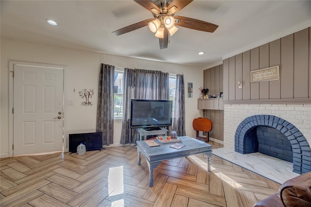 living room featuring a brick fireplace, light parquet floors, and ceiling fan