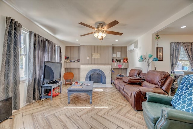 living room with a wall unit AC, ceiling fan, a fireplace, and light parquet floors