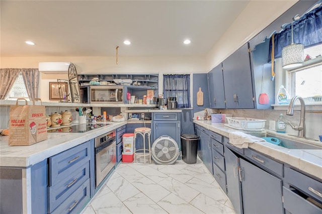 kitchen featuring black electric stovetop, oven, blue cabinets, and sink