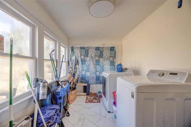 laundry room with washing machine and dryer and a wealth of natural light