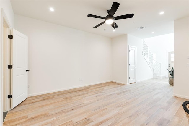 spare room with baseboards, visible vents, stairs, light wood-type flooring, and recessed lighting