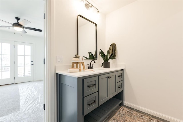 bathroom with ceiling fan, vanity, and baseboards