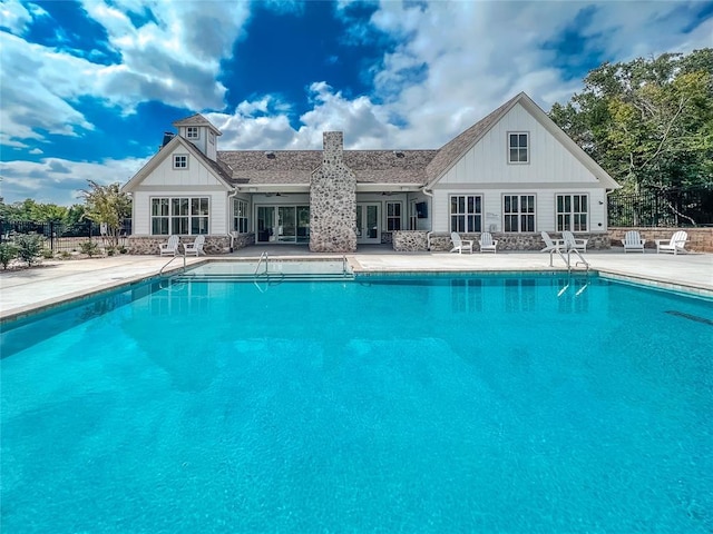 community pool featuring french doors, a patio, and fence