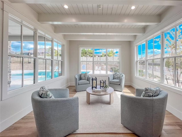 sunroom / solarium featuring a healthy amount of sunlight, wooden ceiling, and beam ceiling