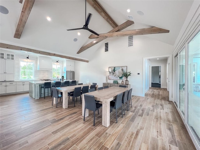 dining area with high vaulted ceiling, beam ceiling, visible vents, and light wood-style floors