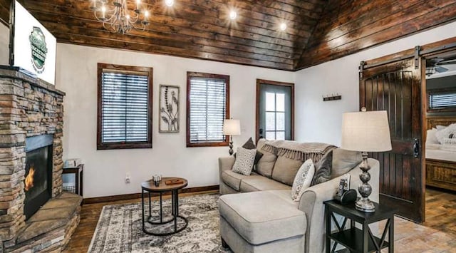 living room featuring a stone fireplace, a barn door, a notable chandelier, hardwood / wood-style floors, and wood ceiling