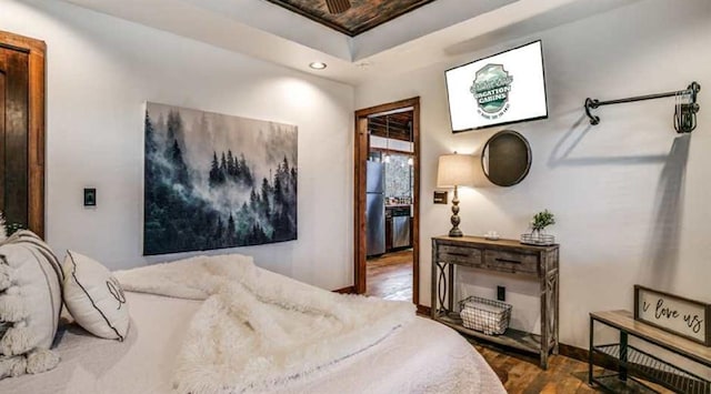 bedroom with stainless steel fridge and hardwood / wood-style flooring